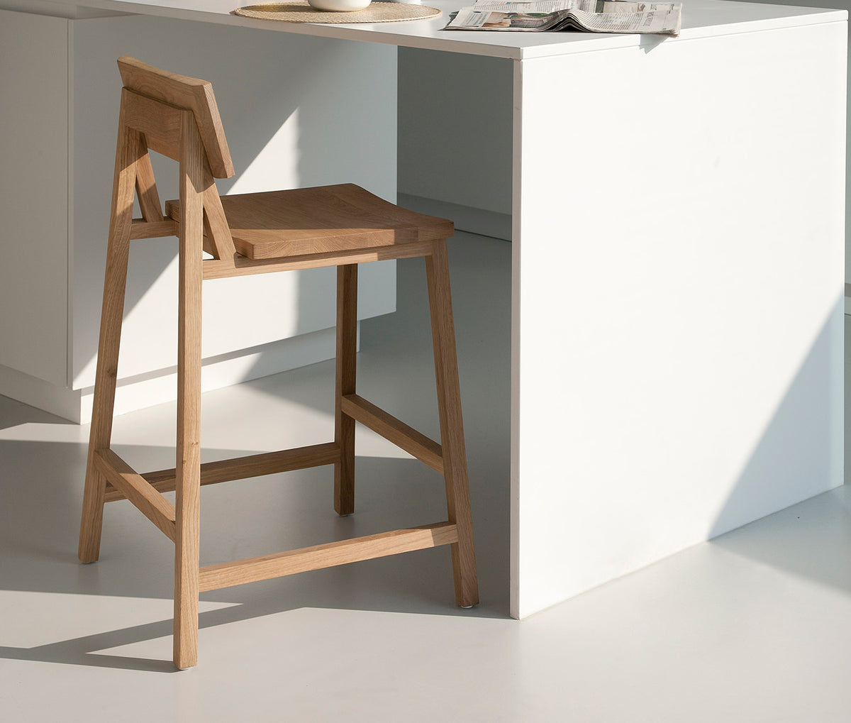 N3 Counter Stool by Ethnicraft, showing angle view of n3 kitchen counter stool in live shot.