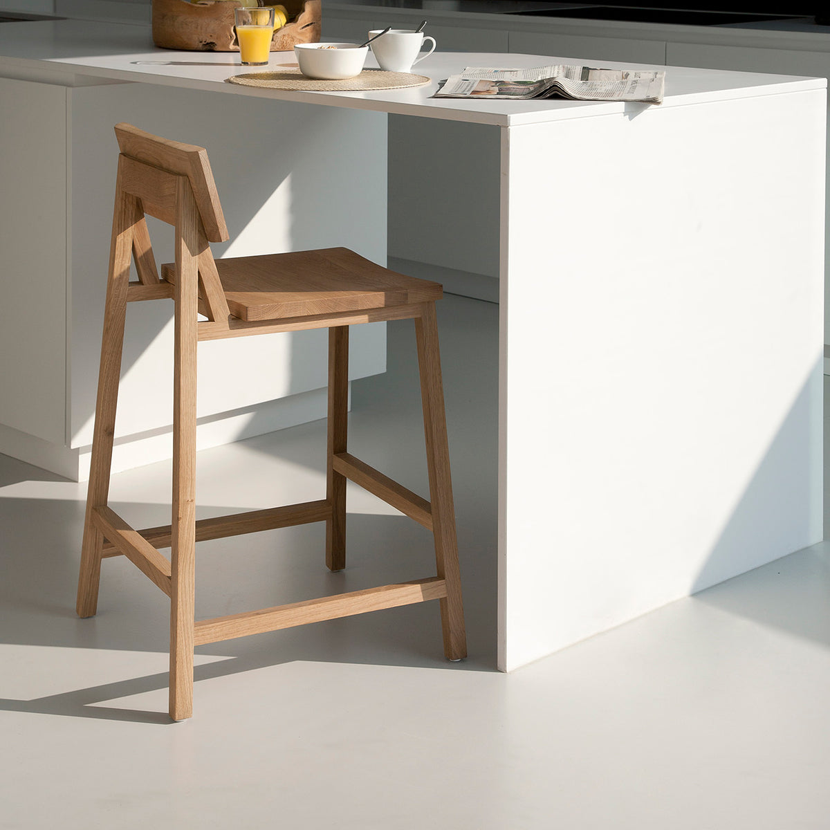 N3 Counter Stool by Ethnicraft, showing angle view of n3 kitchen counter stool in live shot.