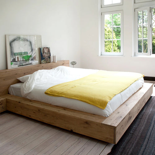 Madra Oak Bed with Slats by Ethnicraft, showing side view of oak bed in the live shot.