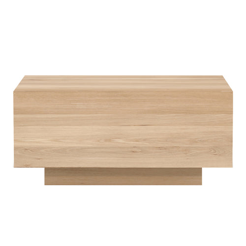Madra Oak Bedside Table by Ethnicraft, showing side view of bedside table with bed.