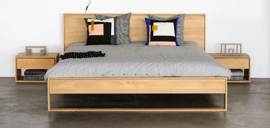 Nordic II Bed with Slats by Ethnicraft, showing front view of nordic oak bed with side table in the live shot.