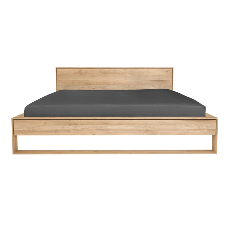 Nordic II Bed with Slats by Ethnicraft, showing front view of nordic oak bed with side table.