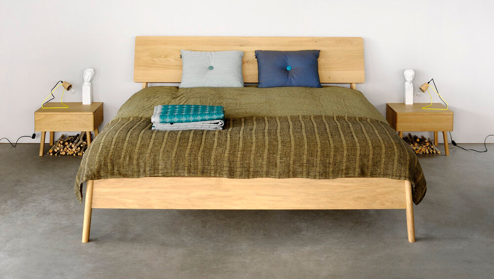 Air Oak Bedside Table by Ethnicraft, showing front view of bedside table with bed in the live shot.