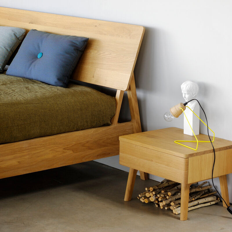 Air Oak Bedside Table by Ethnicraft, showing side view of air oak bedside table with bed in room shot.