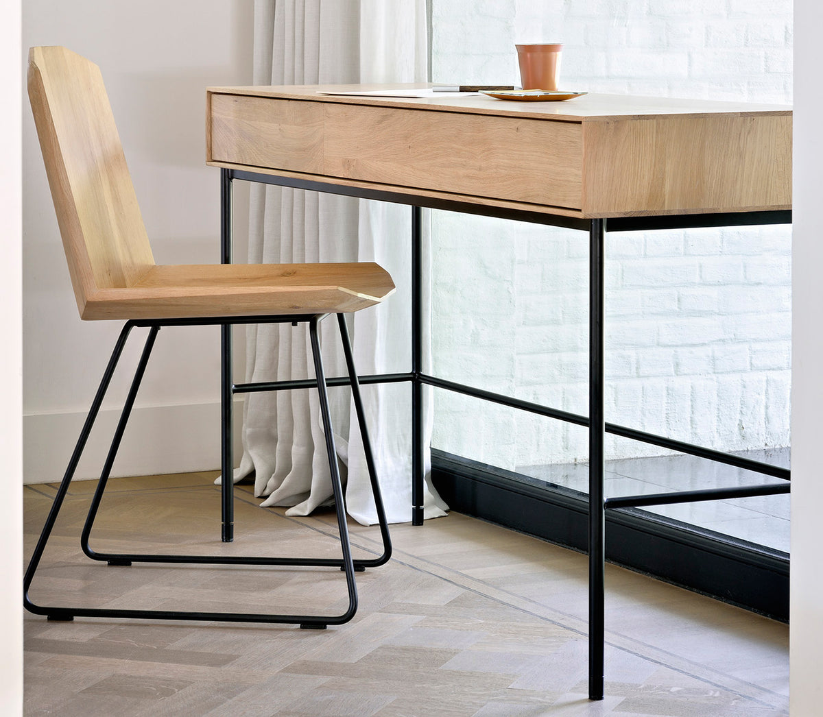 Whitebird Desk by Ethnicraft, showing angle view of oak desk - 2 drawers and chair in live shot.