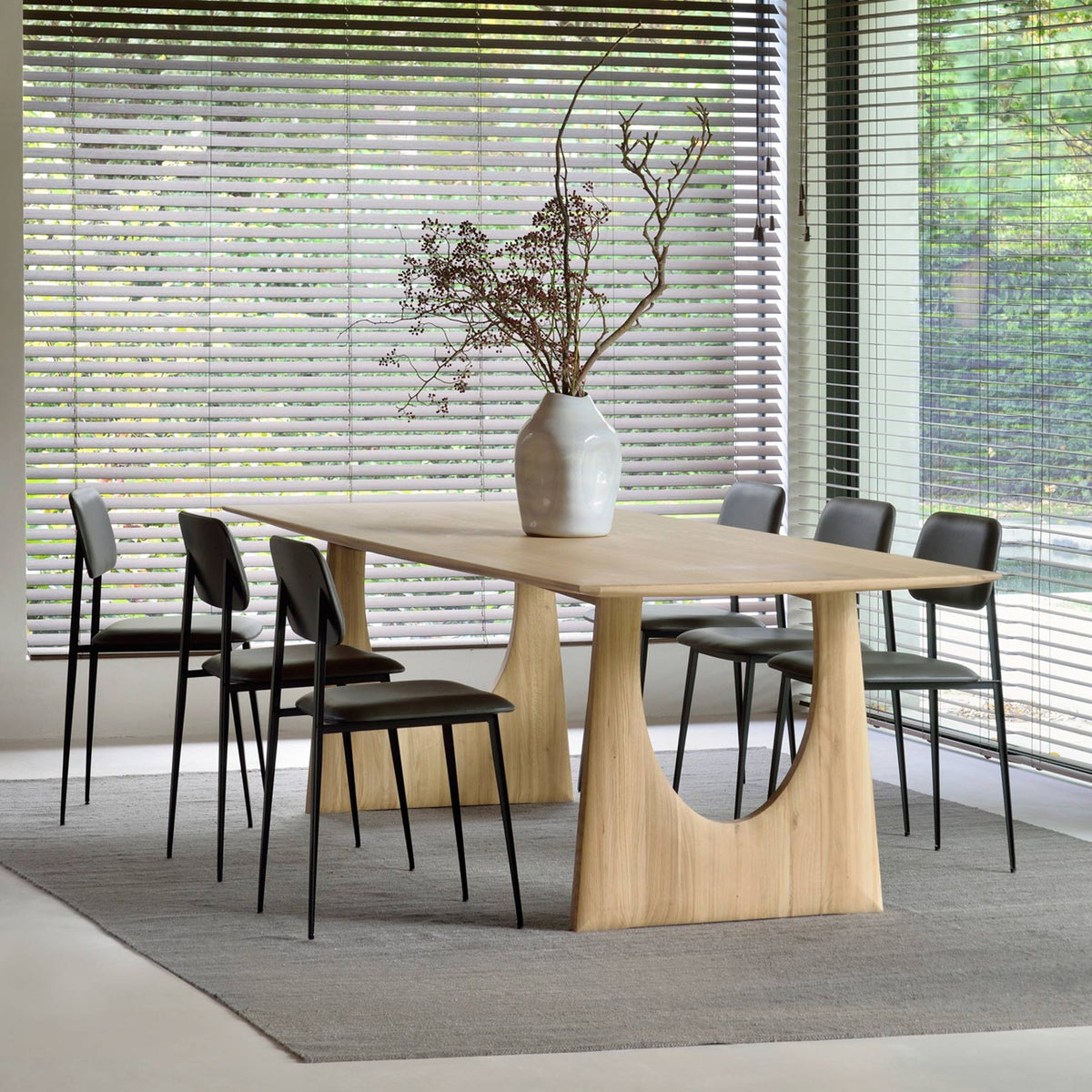 Geometric Dining Table by Ethnicraft, showing angle view of geometric dining table with chairs in live shot.