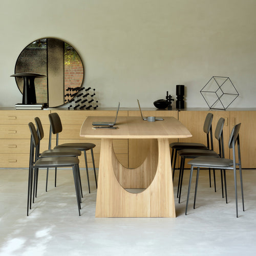 Oak Geometric Dining Table by Ethnicraft, showing side view of geometric dining table with chairs in live shot.