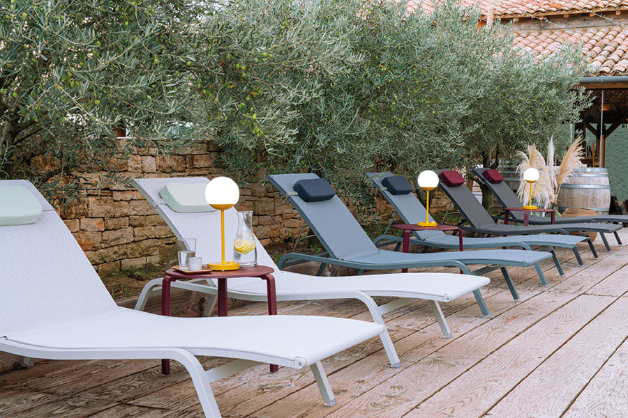 Alize Stacking Low Table by Fermob, showing stacking low tables with sunloungers in live shot.
