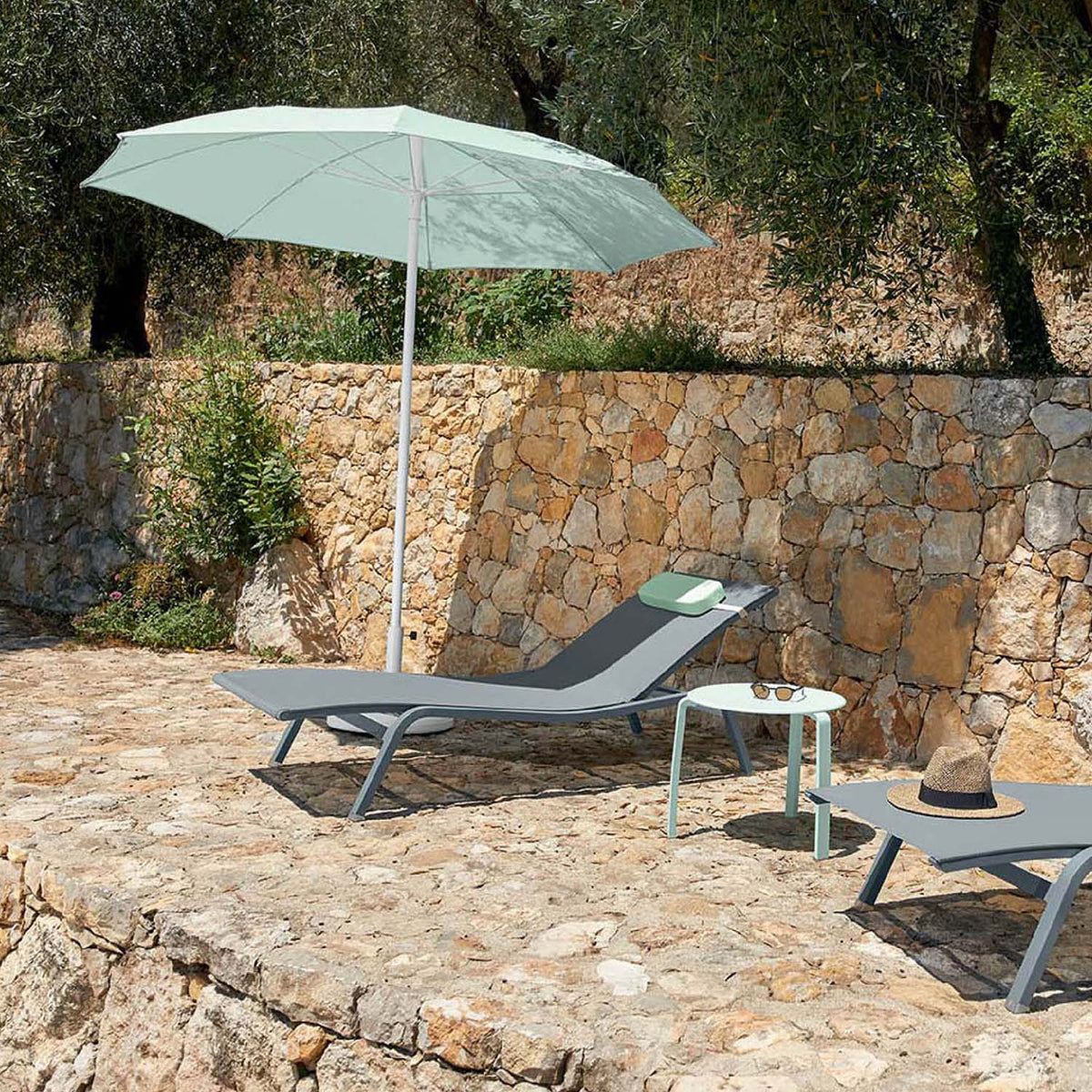 Alize Stacking Low Table by Fermob, showing stacking low tables with sunloungers in live shot.