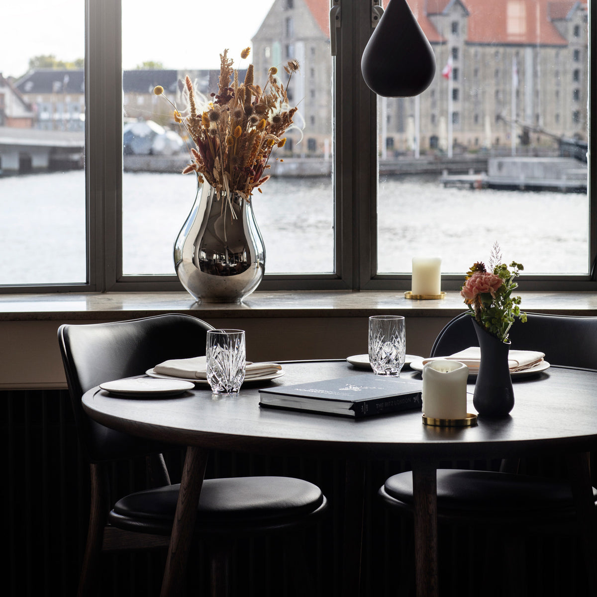 Accent Dining Table by Mater, showing closeup view of accent dining table with chairs in live shot.