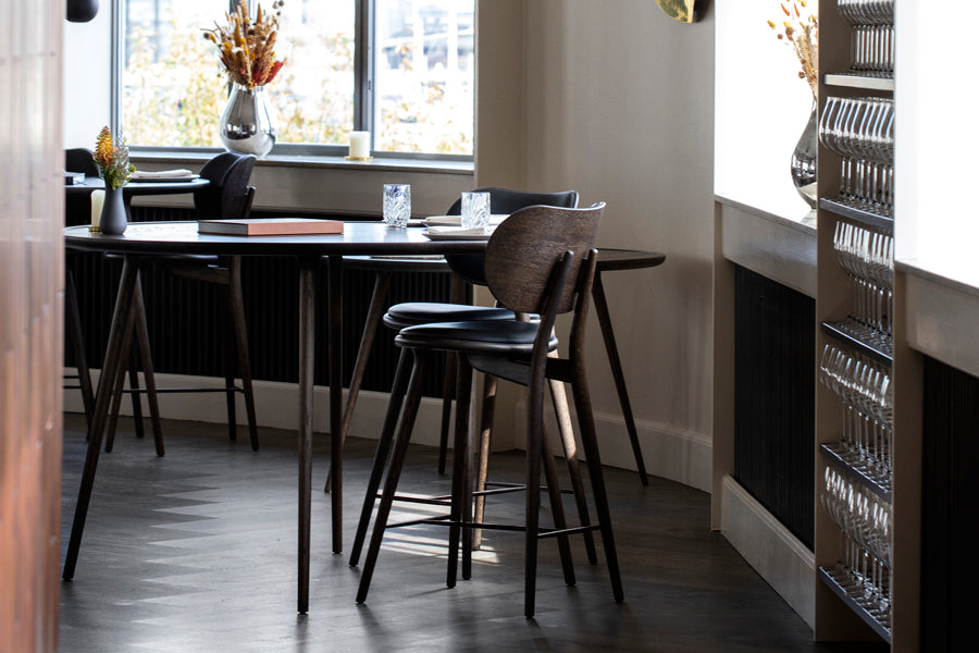 Accent Dining Table by Mater, showing closeup view of accent dining table with chairs in live shot.