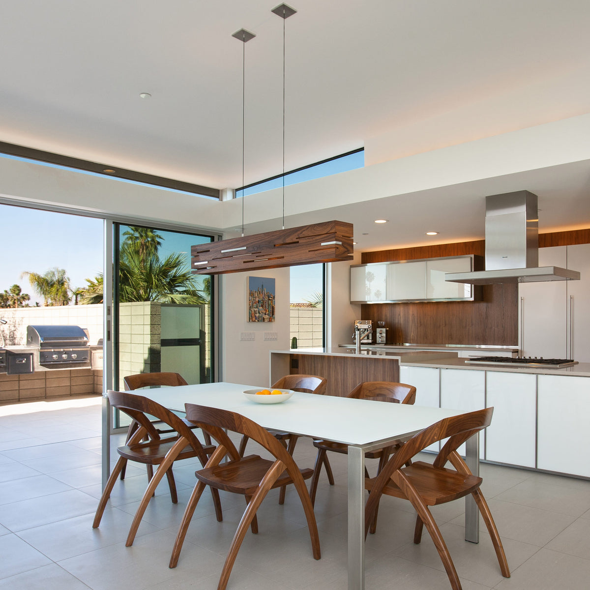 Aeris LED Linear Pendant by Cerno, showing aeris led linear pendant with table & chairs in live shot.
