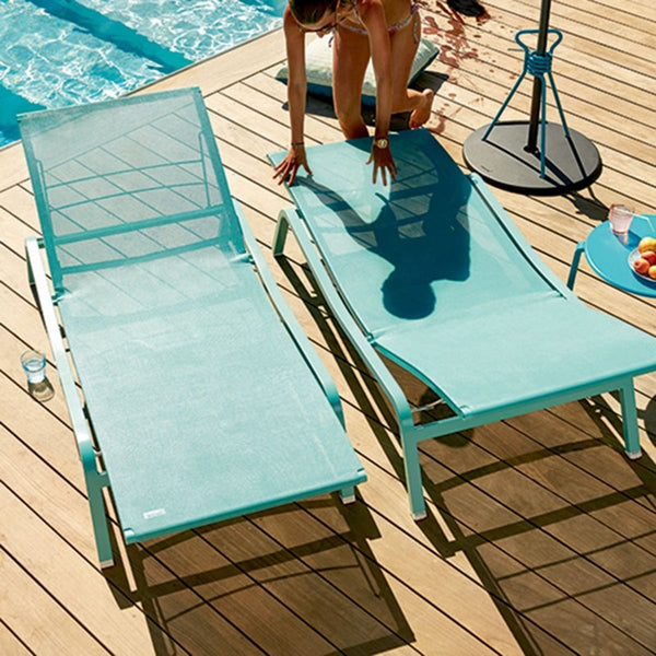 Alize Stacking Low Table by Fermob, showing stacking low table with sunloungers in live shot.
