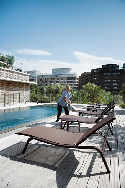 Alize Stacking Low Table by Fermob, showing stacking low tables with sunloungers in live shot.
