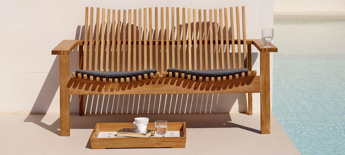 Amaze Stackable 2-Seater Sofa by Cane-Line, showing amaze stackable 2-seater sofa with cushions & table tray in live shot.