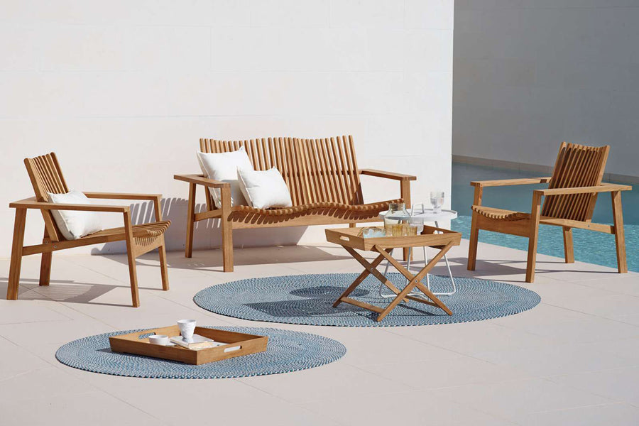 Amaze Stackable Lounge Chair by Cane-Line, showing amaze stackable lounge chairs with 2-seater & side table in live shot.