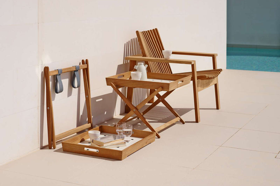 Amaze Stackable Lounge Chair by Cane-Line, showing amaze stackable lounge chair with side tables in live shot.