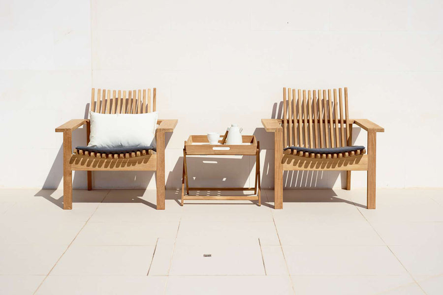 Amaze Stackable Lounge Chair by Cane-Line, showing amaze stackable lounge chairs with side table in live shot.