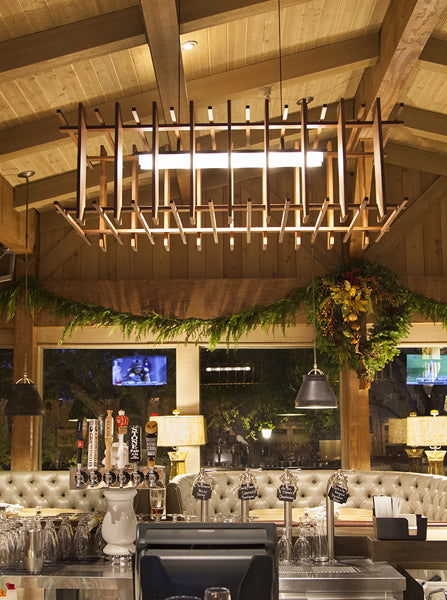 Arca LED Linear Pendant by Cerno, showing arca led linear pendant with sofas in live shot.