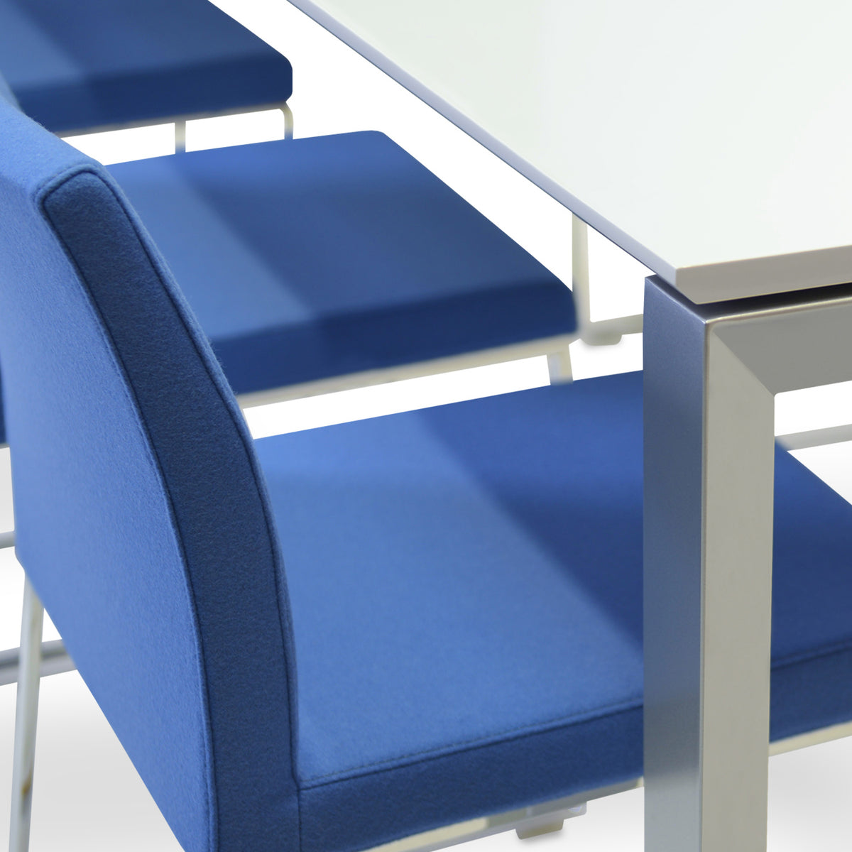 Aria Sled Wire Dining Chair by SohoConcept, showing closeup view of sleg dining chairs with table.