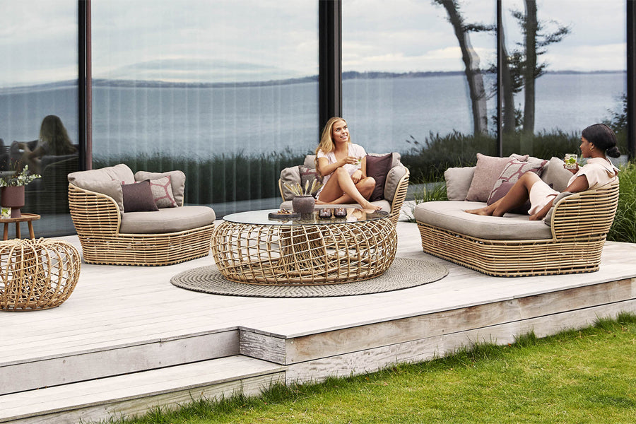 Basket 2-Seater Sofa by Cane-Line, showing of basket 2-seater sofa with chair & tables in live shot.