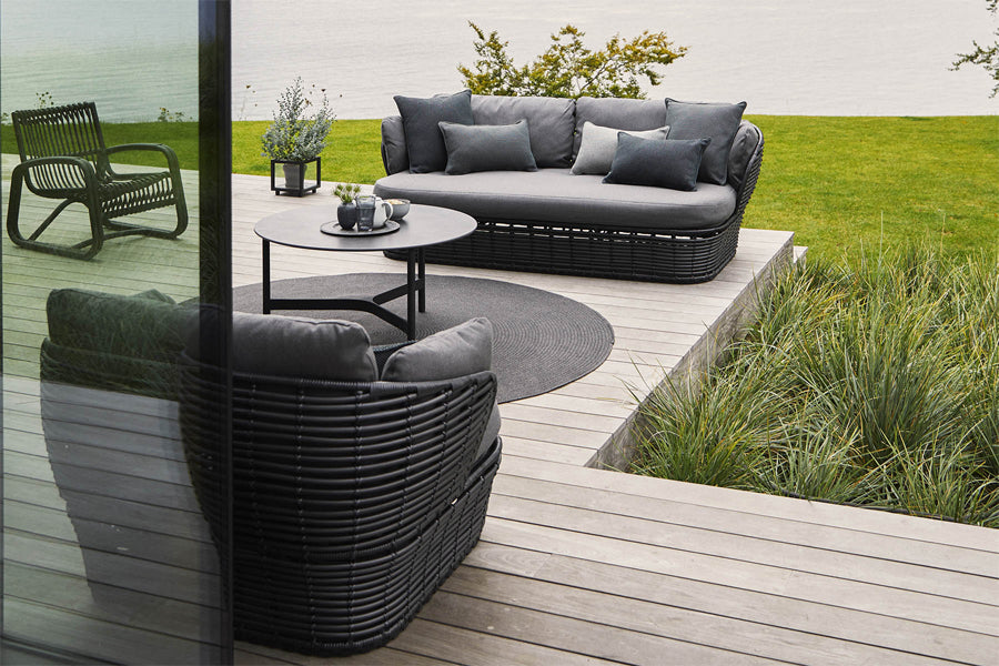 Basket 2-Seater Sofa by Cane-Line, showing of basket 2-seater sofa with chair & tables in live shot.
