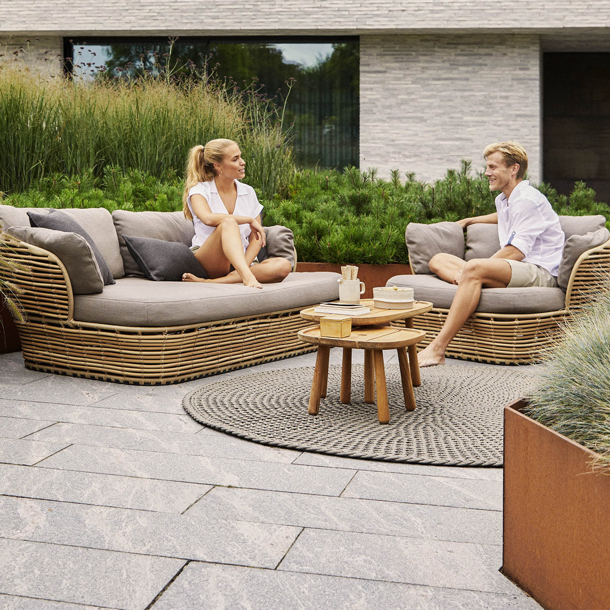 Basket Lounge Chair by Cane-Line, showing of basket lounge chair with tables & sofa in live shot.