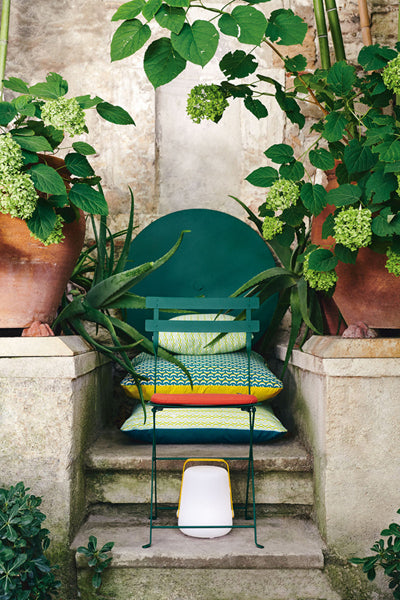 Bistro Metal Chair by Fermob, showing bistro metal chair with pillows in live shot.