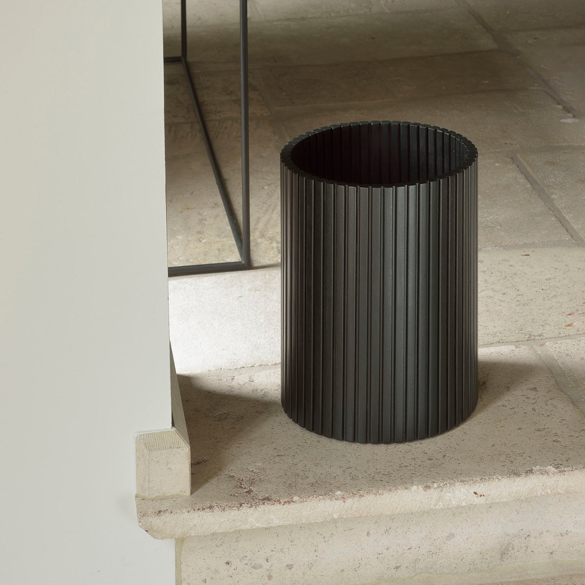 Black Waste Paper Basket by Ethnicraft, showing front view of basket in the live shot.
