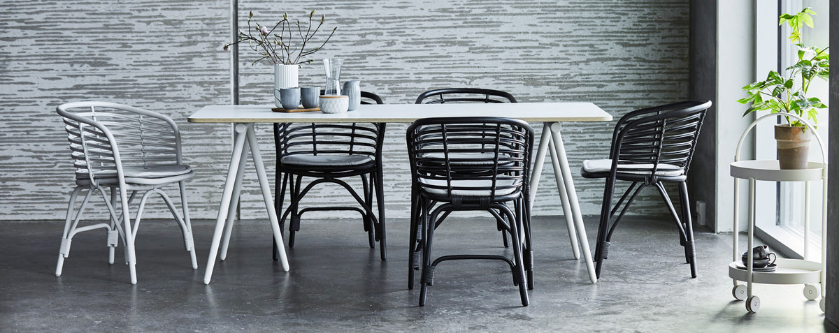 Blend Indoor Armchair by Cane-Line, showing blend indoor armchairs with table in live shot.