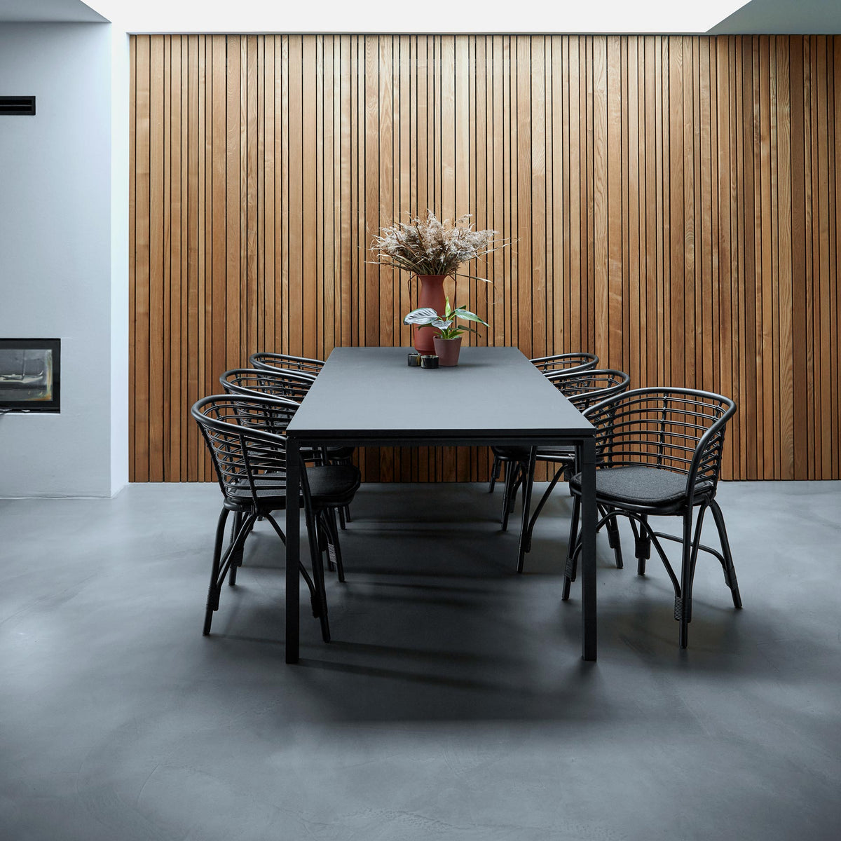 Blend Indoor Armchair by Cane-Line, showing blend indoor armchairs with table in live shot.