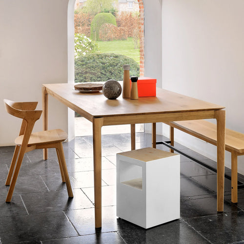 Bok Dining Table by Ethnicraft, showing side view of natural oak dining table with dining chairs in the live shot.