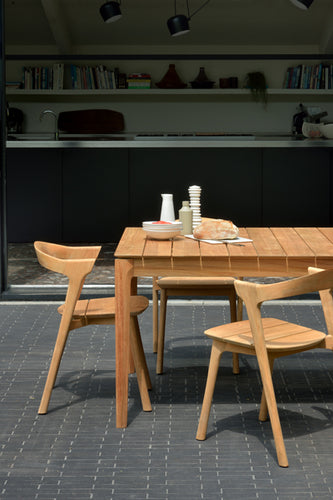 Bok Teak Outdoor Dining Table by Ethnicraft, showing closeup view of teak outdoor dining table with chairs in live shot.
