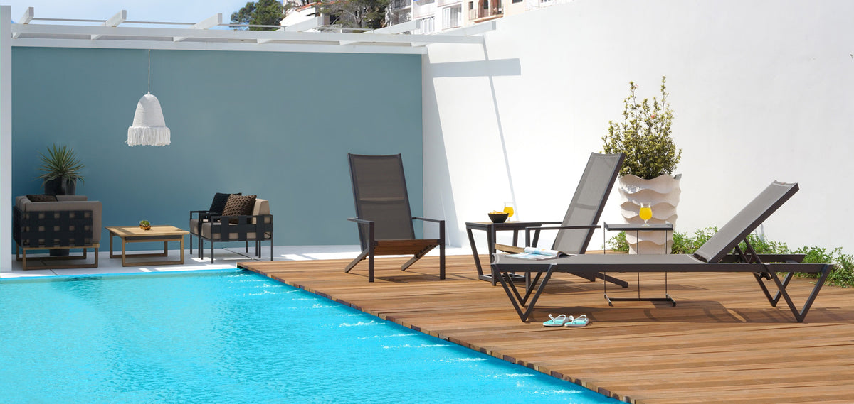 Bondi Ledge Stackable Sling Sunbed by Mamagreen, showing bondi ledge stackable sling sunbed with chairs & tables in live shot.