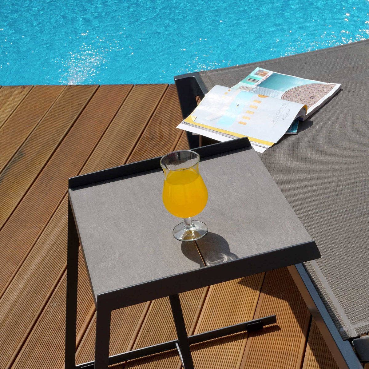 Bondi Ledge Stackable Sling Sunbed by Mamagreen, showing closeup view of bondi ledge stackable sling sunbed with table in live shot.