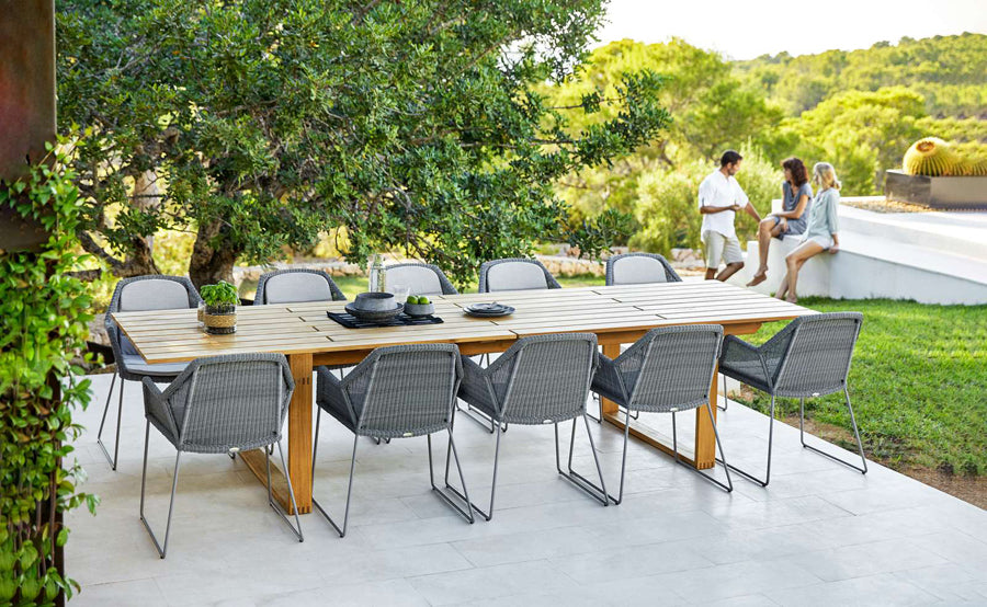 Breeze Dining Chair by Cane-Line, showing breeze dining chairs with table in live shot.