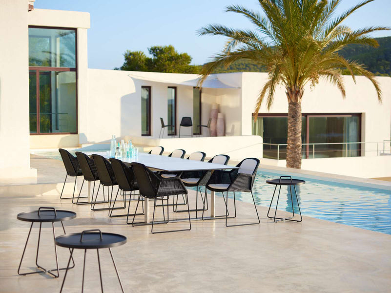 Breeze Dining Chair by Cane-Line, showing breeze dining chairs with table in live shot.