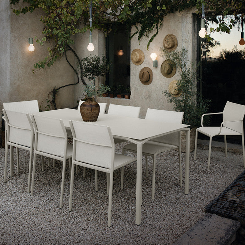 Calvi Dining Table by Fermob, showing of calvi dining table with chairs in live shot.