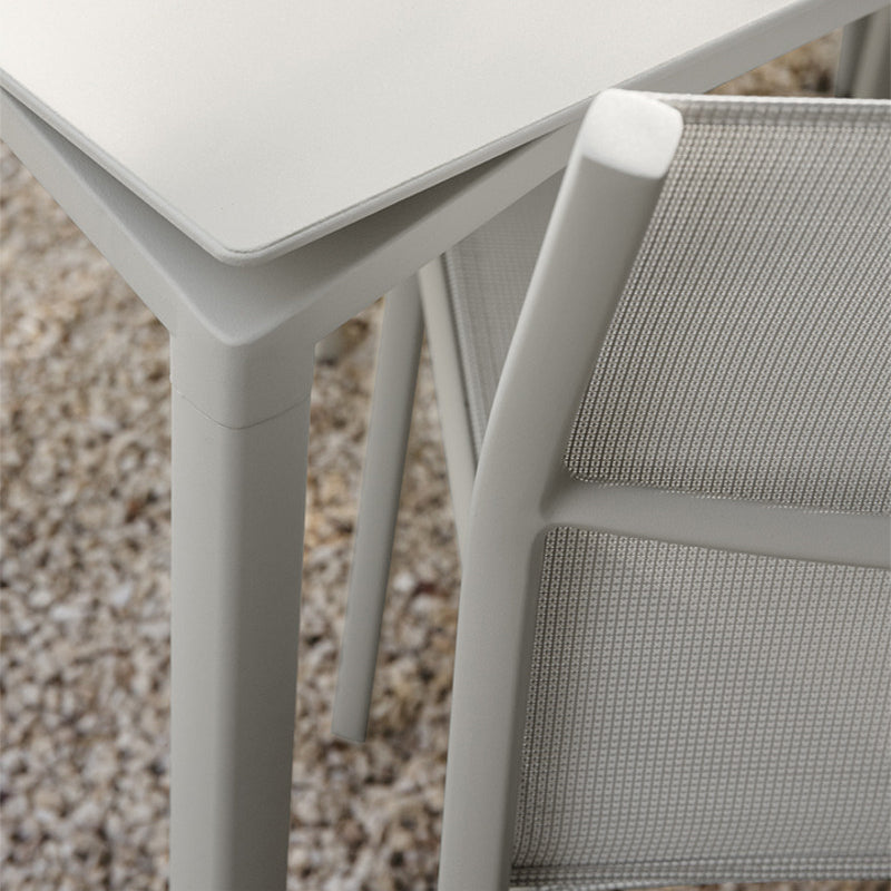 Calvi Dining Table by Fermob, showing close up view of calvi dining table with chair in live shot.