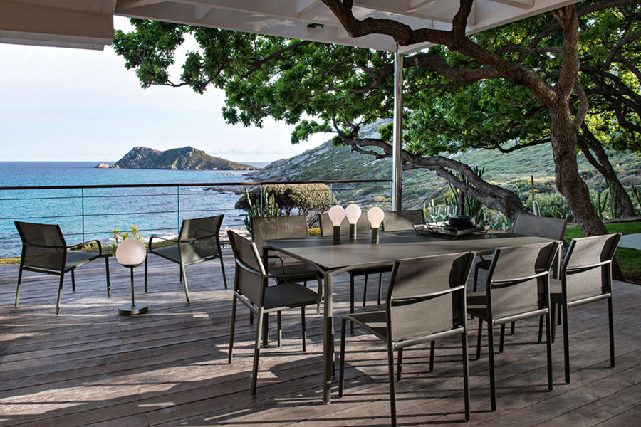 Calvi Dining Table by Fermob, showing of calvi dining table with chairs in live shot.