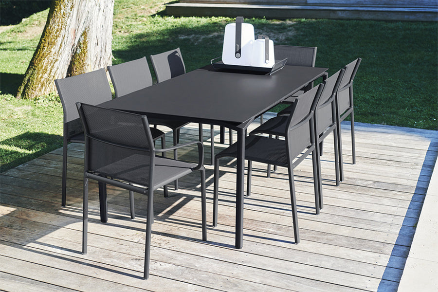 Calvi Dining Table by Fermob, showing angle view of calvi dining table with chairs in live shot.