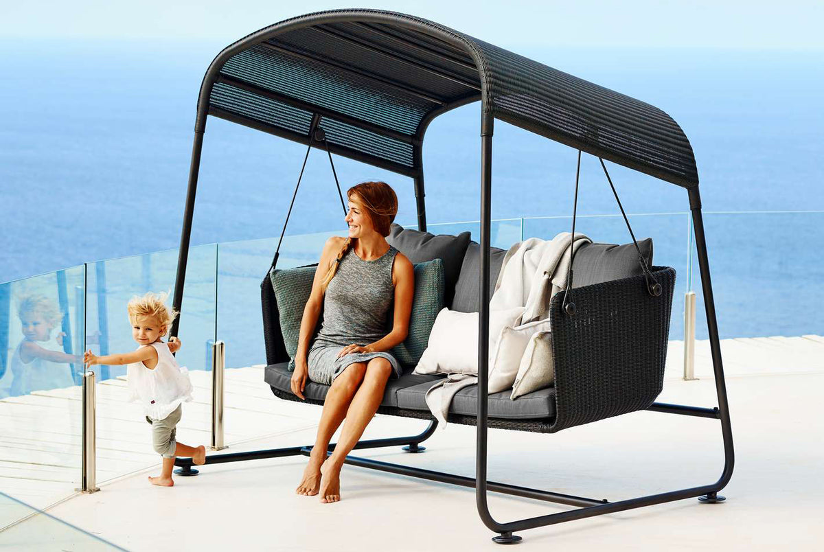 Cave Outdoor Swing Sofa by Cane-Line, showing cave outdoor swing sofa in live shot.