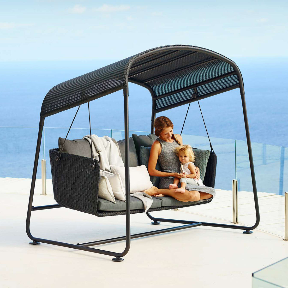 Cave Outdoor Swing Sofa by Cane-Line, showing cave outdoor swing sofa in live shot.