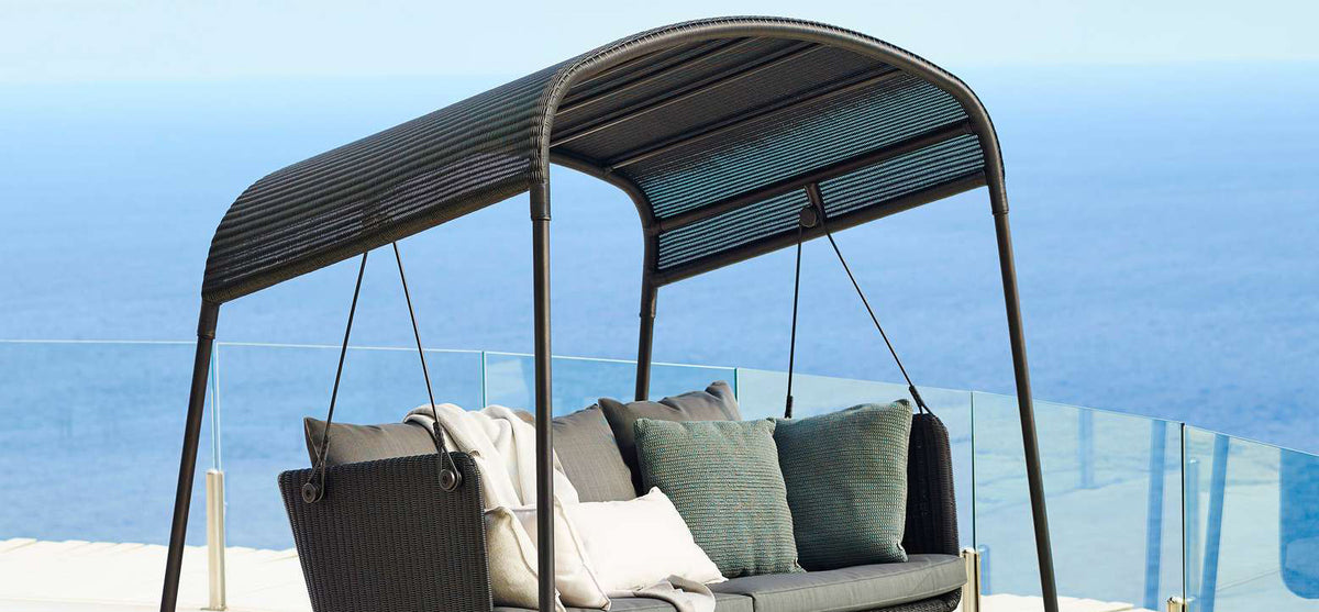 Cave Outdoor Swing Sofa by Cane-Line, showing cave outdoor swing sofa in live shot.