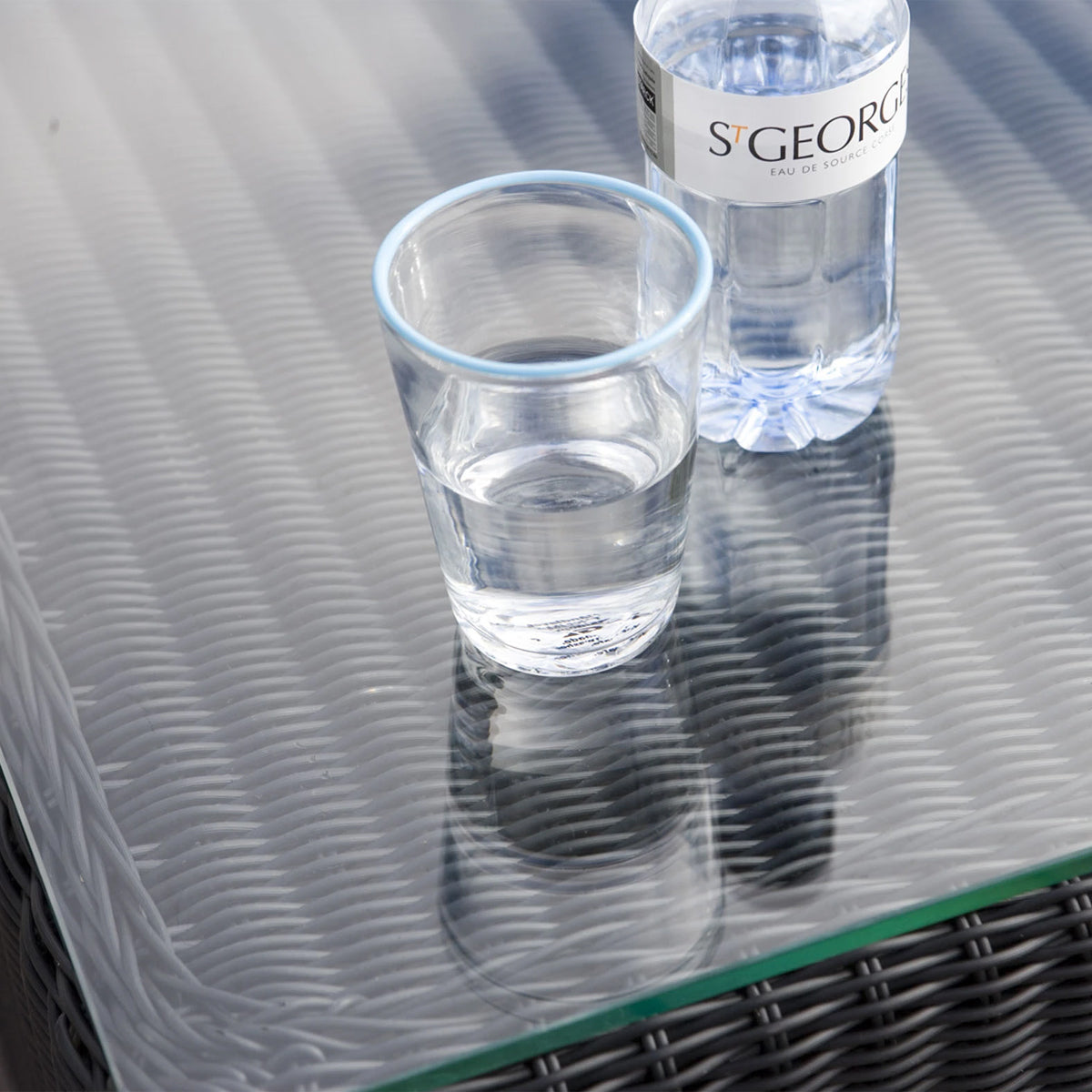 Chester Clear Glass Coffee Table by Cane-Line - showing closeup view of chester clear glass coffee table in live shot.