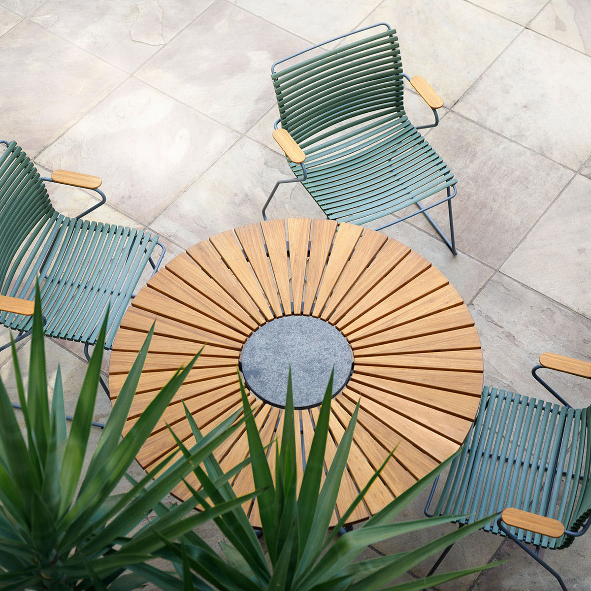 Circle Outdoor Dining Table by Houe, showing circle outdoor dining table with dining chairs in live shot.