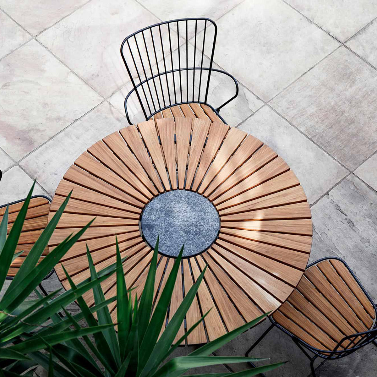 Circle Outdoor Dining Table by Houe, showing circle outdoor dining table with dining chairs in live shot.