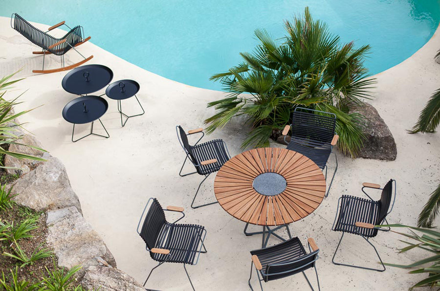Circle Outdoor Dining Table by Houe, showing circle outdoor dining table with dining chairs in live shot.