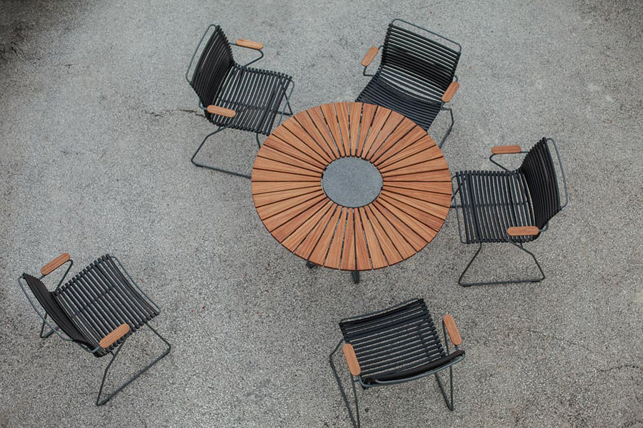 Circle Outdoor Dining Table by Houe, showing circle outdoor dining table with dining chairs in live shot.