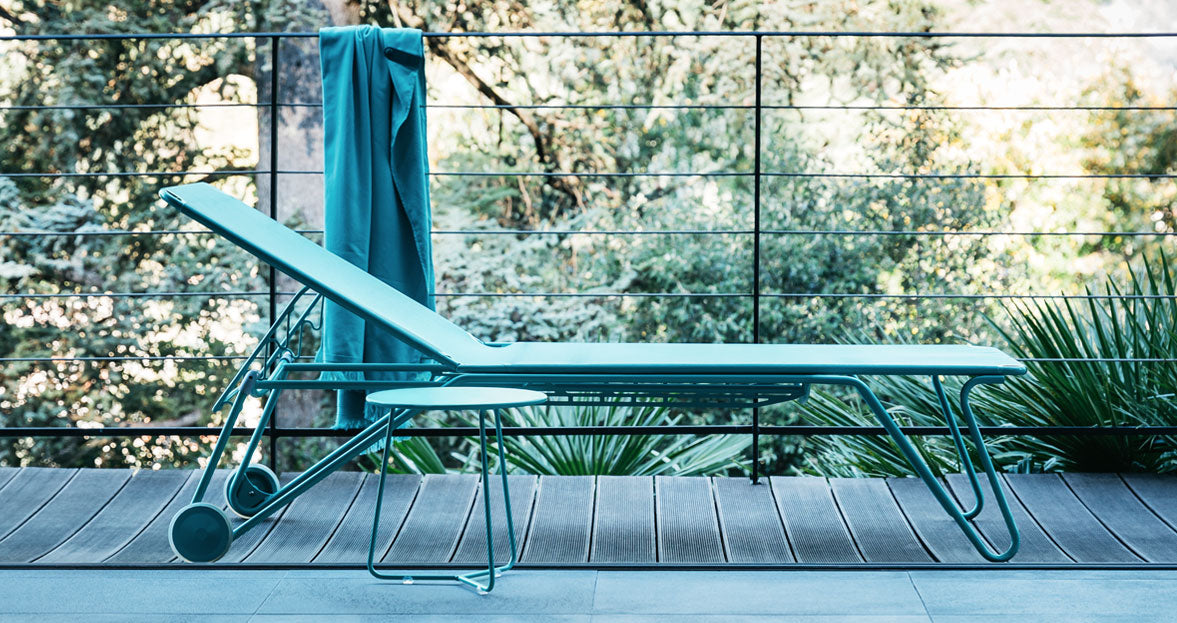 Cocotte Small Side Table by Fermob, showing front view of small side table with sunlounger in the live shot.